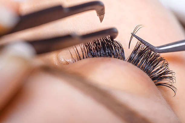 Eyelash extension application process with tweezers and a comb.